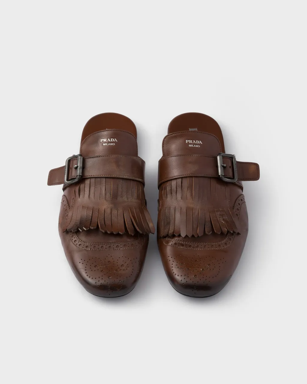 Shuffle Antiqued Leather Mules With Buckled Strap And Fringe