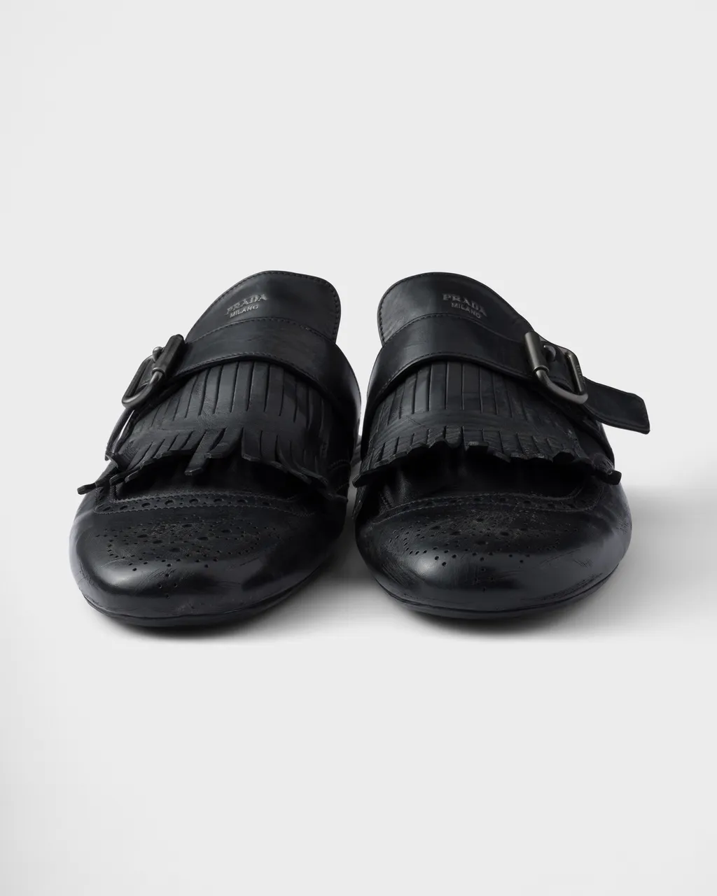Shuffle Antiqued Leather Mules With Buckled Strap And Fringe