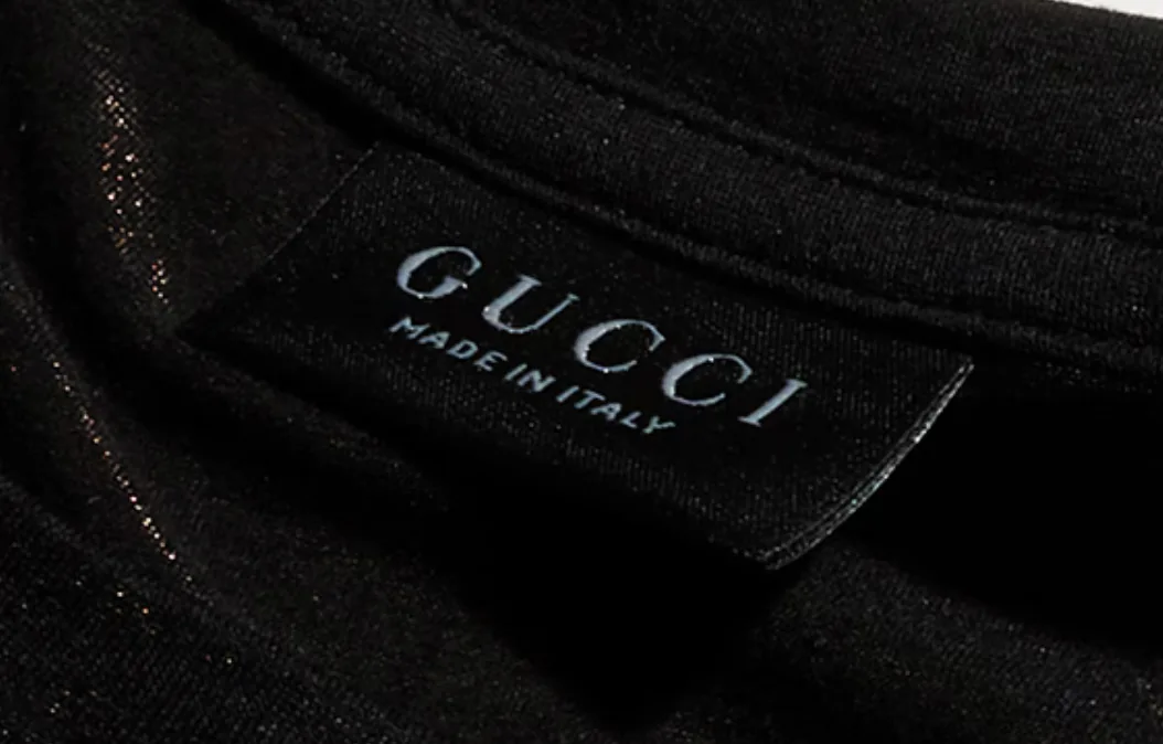 Black Gucci neck label with GUCCI above MADE IN ITALY in muted grey lettering