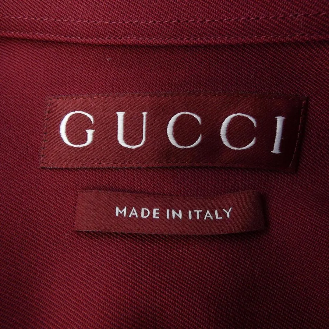 Oxblood red Gucci neck label with GUCCI in white serif capitals above a separate red tab reading MADE IN ITALY
