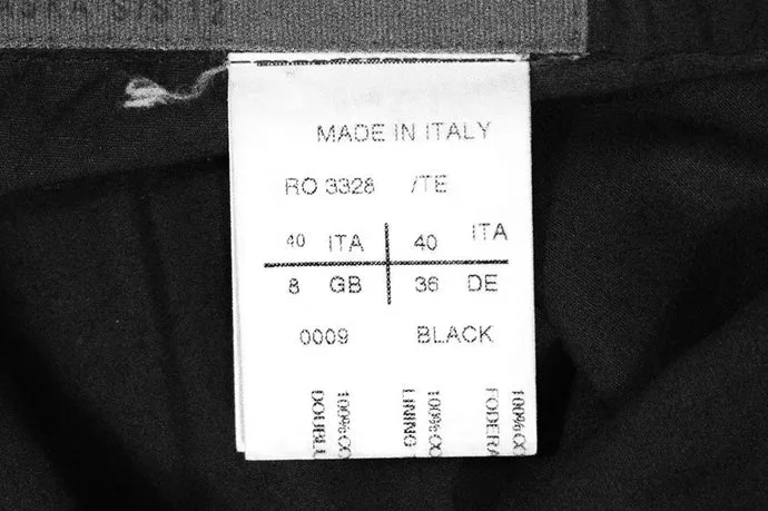 Rick Owens white care label on a black garment, printed MADE IN ITALY above RO 3328 /TE, a size grid reading 40 ITA, 8 GB, 40 ITA, 36 DE, and 0009 BLACK