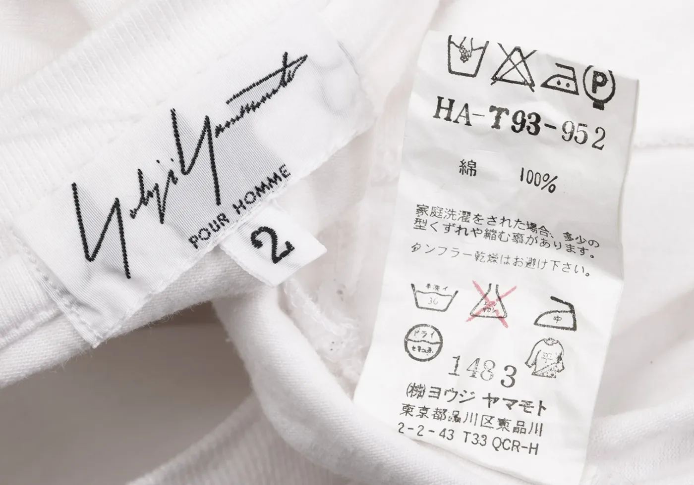 Yohji Yamamoto signature neck label reading POUR HOMME with a size tab marked 2, beside a Japanese care label printed HA-T93-952, 綿 100%, care symbols, the number 1483 and the company name ヨウジヤマモト with a Shinagawa Tokyo address